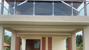 Un bâtiment à deux étages doté d’un balcon couvert et d’une fenêtre ornée d’une grille métallique.