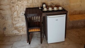 A small kitchenette with a refrigerator, a wooden table, and a chair. - SUMATRA OTEL (Şanlıurfa)