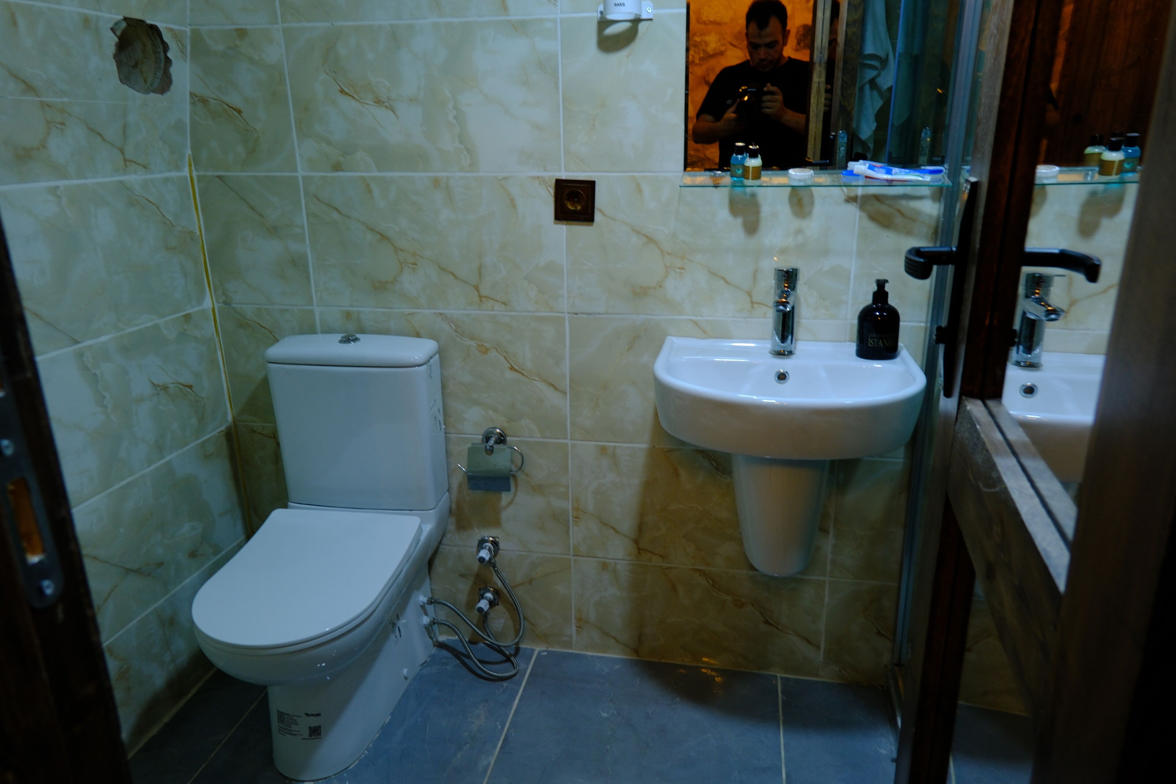 Un baño con inodoro, lavamanos y espejo.