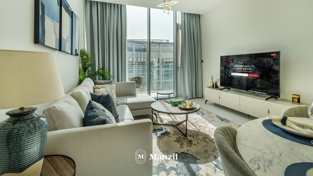 A modern living room with a sofa, coffee table, and TV. - Manzil - Lux 1BR minutes to Dubai Mall (Dubai)