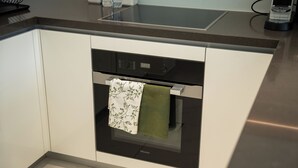 A kitchen with a built-in oven and a microwave. - Manzil - Lux 1BR minutes to Dubai Mall (Dubai)