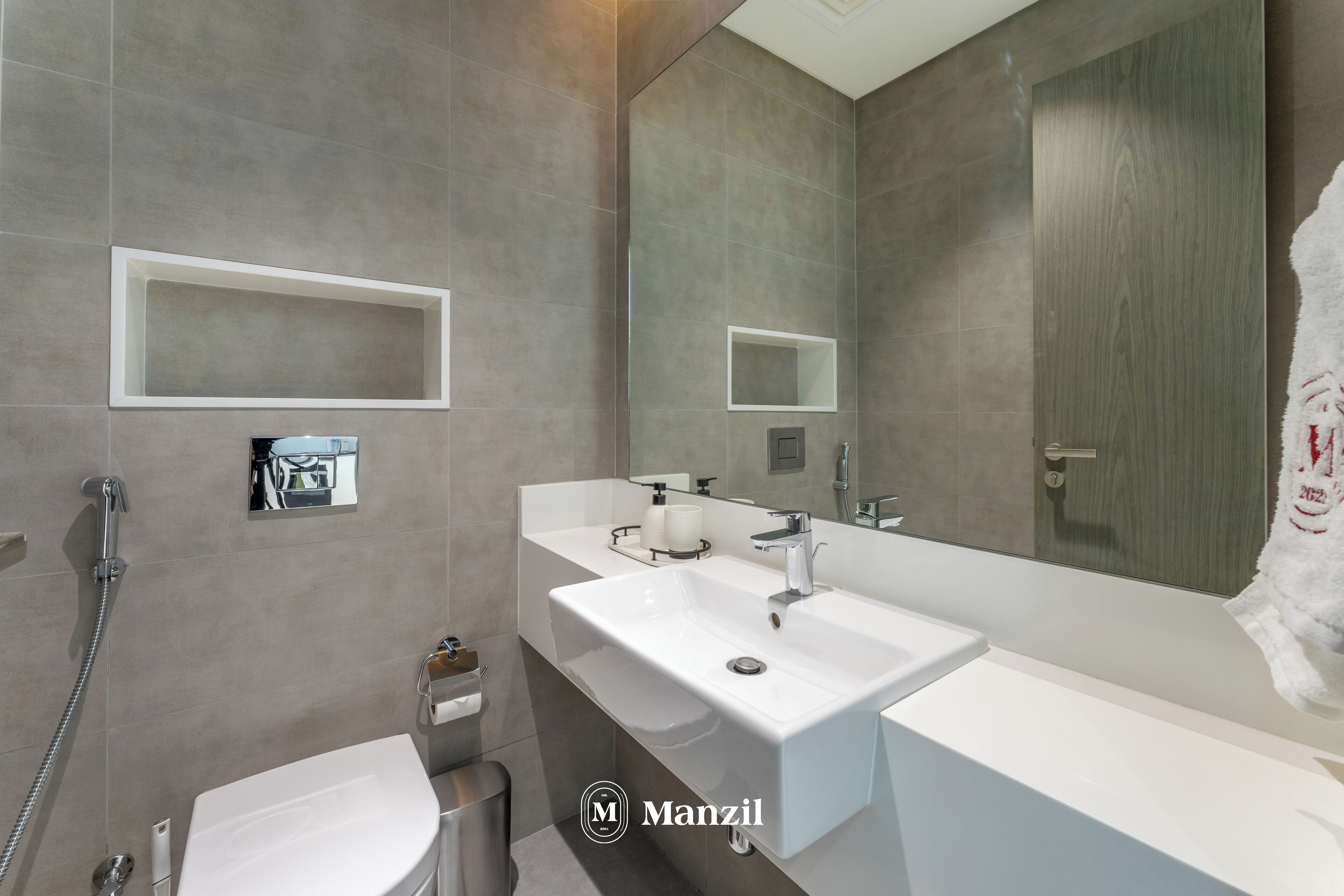 Ein modernes Badezimmer mit zwei Waschbecken, einem großen Spiegel und einer Dusche.