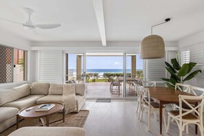 Un salon moderne avec un canapé, une table basse et un coin repas.