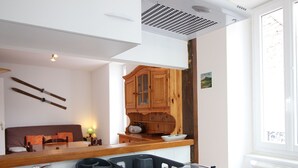 A compact kitchen with a built-in stove, a sink, and wooden cabinets. - F2 with WIFI downtown near spa (Mont-Dore)