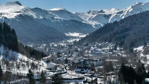Een stadje gelegen in een vallei, met besneeuwde bergen op de achtergrond.