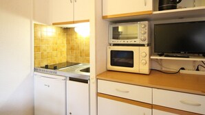 A compact kitchen with white cabinets, a microwave, a toaster, and a coffee maker. - Studio at Mont-Dore slopes, 4 pers. (Mont-Dore)