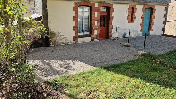 A building with a sloped roof, a red door, and a small fenced area in front. - F2 Apartment with terrace and garden, near Mont-Dore center (Mont-Dore)