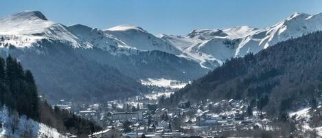 A town nestled in a valley with snow-covered mountains in the background.