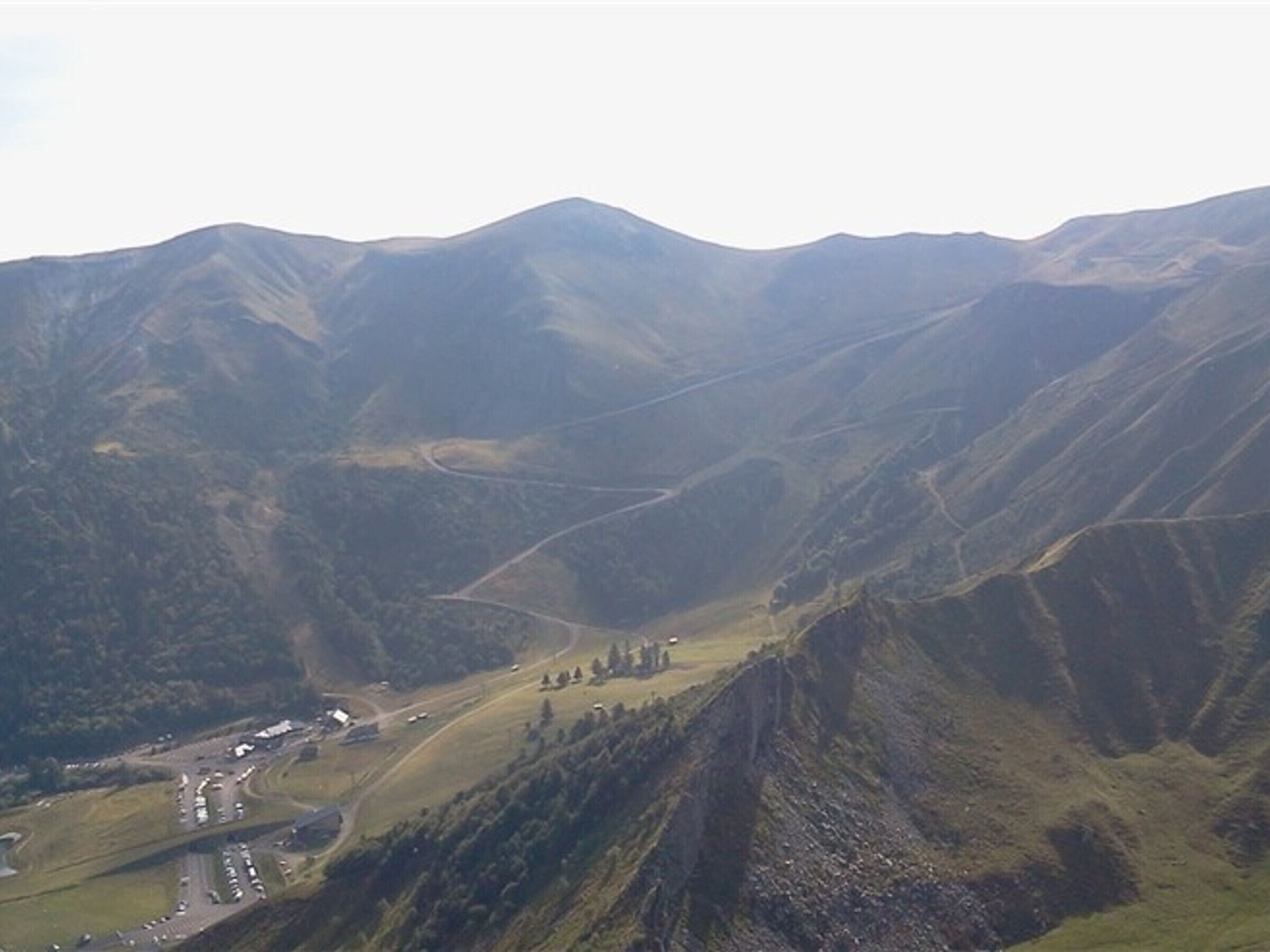 A mountainous landscape with a winding road and a small settlement.
