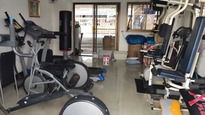 Un gimnasio con bicicletas estáticas, elípticas y equipos de pesas.