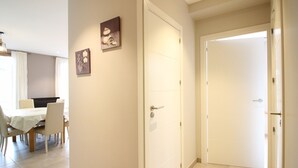 En hall med ett matområde, två dörrar och en lampa.