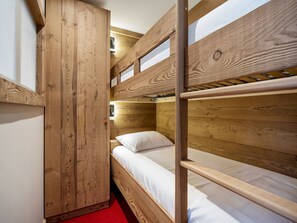 A bunk bed room with wooden walls and a red carpet. - Ski-in/Ski-out Apartment in Val Thorens with WIFI (Val Thorens)