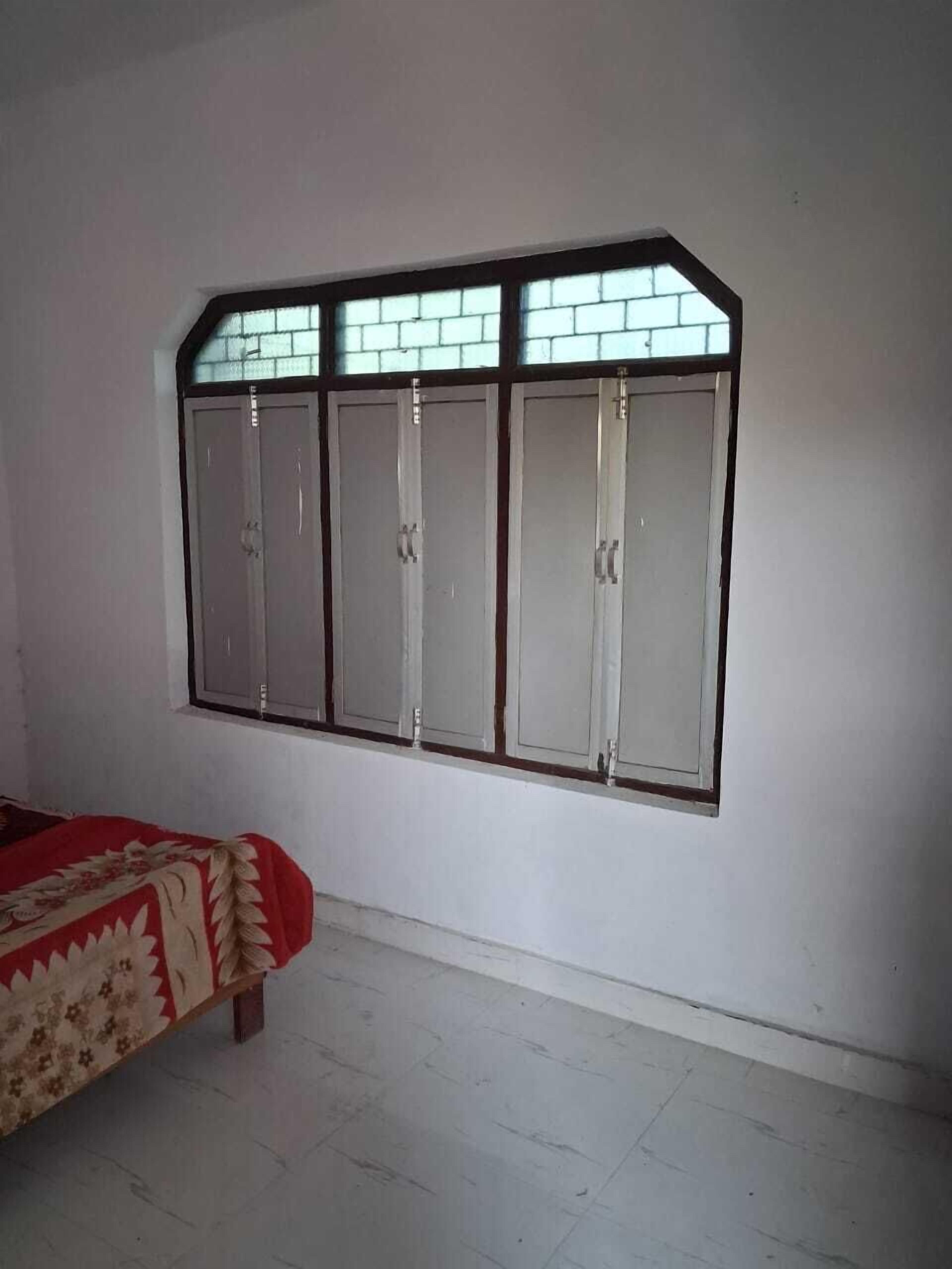 A room with a bed, a window with a view, and a wardrobe.