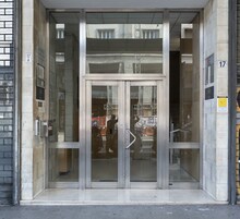 L'ingresso di un edificio con una porta in vetro e una struttura in metallo.