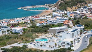 A coastal residential area with modern houses, a swimming pool, and a marina. - AmphiMatrion, Kriti penthouse luxury apartment, w/ hot tub and Sea View (C5XG+MHV Kalyves, Greece)