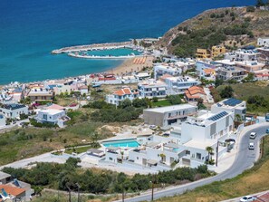 A coastal residential area with modern houses, a swimming pool, and a marina. - AmphiMatrion, Kriti penthouse luxury apartment, w/ hot tub and Sea View (C5XG+MHV Kalyves, Greece)