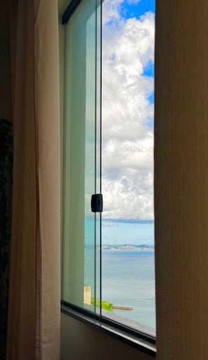 A room with a large window overlooking a body of water and a distant shoreline. - Stylish loft in the historic center of Salvador—within walking distance of Pelourinho (Salvador)