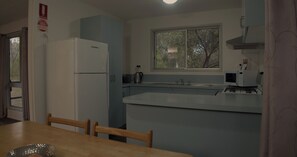 A compact kitchen with a refrigerator, sink, and window. - Scenic Rim Motel (Aratula)