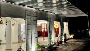 Un edificio moderno con fachada de vidrio, una escalera y plantas en macetas.