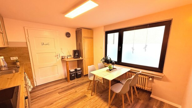 A compact kitchen with a dining area, a built-in oven, and a window with a view. - Cozy vacation apartment in Nideggen-Berg (Nideggen)