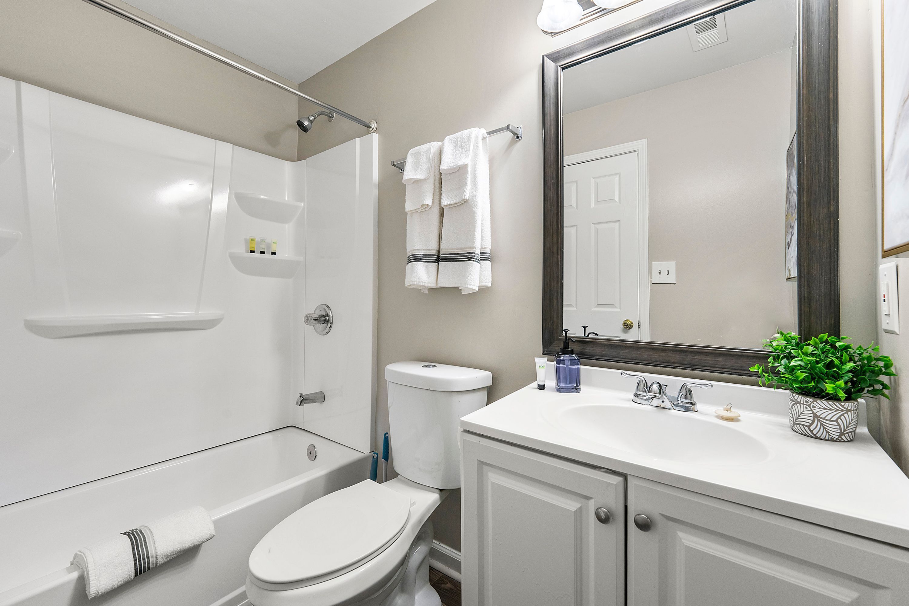 A modern bathroom with a bathtub, toilet, and sink.