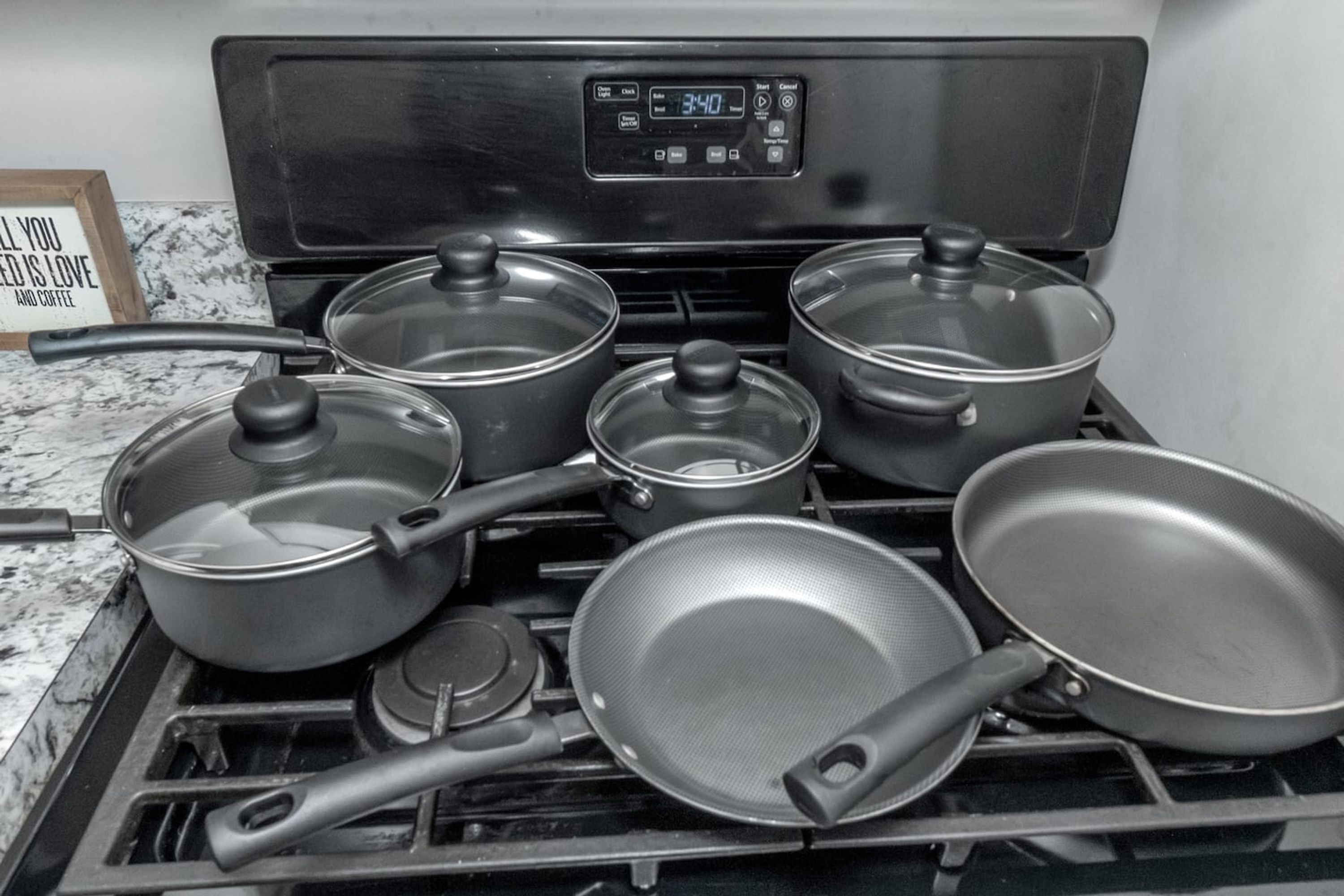 A kitchen with four pots and pans on a stove.