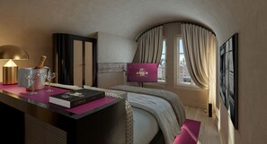 A hotel room with a bed, a desk with a lamp, a book, a bottle, and a window with curtains. - La Maison (Salzburg)