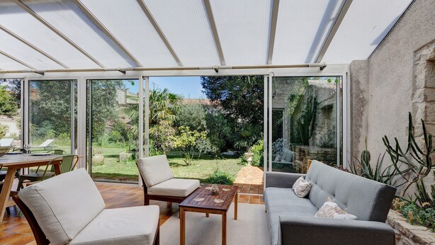A covered patio with a table, chairs, and a sofa. - Holiday Home “La Maison De Famille” with Private Terrace, Garden & Wi-Fi (Luçon)