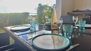 Ett bord dukat för två personer, med en flaska vin, vackra glas och utsikt över omgivningen.
