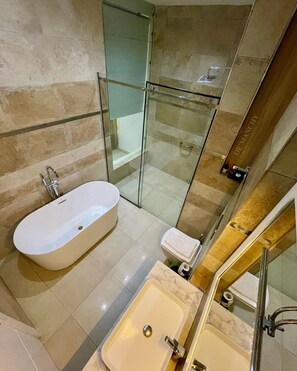 Bañera con ducha, toallas, jabón, shampoo