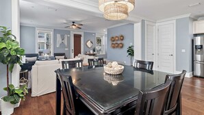 A modern dining area with a glass-top table, dark chairs, and a woven pendant light. - Walk to the Community Pool! 4 Bikes & Golf Cart! Book Today! - Shoreline at Highland Parks (Santa Rosa Beach)