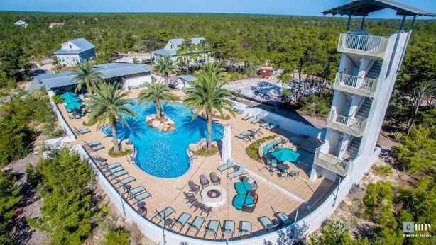 An aerial view of a resort with a central swimming pool, lounge areas, and a multi-story building with balconies. - Walk to the Community Pool! 4 Bikes & Golf Cart! Book Today! - Shoreline at Highland Parks (Santa Rosa Beach)