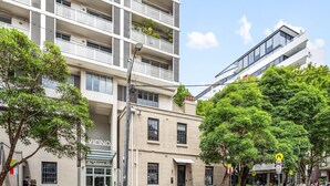 A modern building with a storefront labeled "VICINO" and a car parked in front. - Bright Stay in Sydney With Harbour Bridge Views (Sydney)