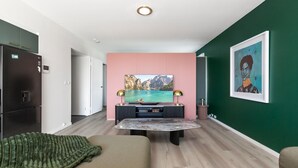 A modern living room with a flat-screen TV, a coffee table, and a sofa. - Bright Stay in Sydney With Harbour Bridge Views (Sydney)