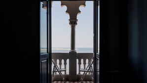 An open doorway leading to a balcony with a checkered floor and two chairs. - Grey l studio apartments Corniche Alexandria Little Venice (Alexandria)