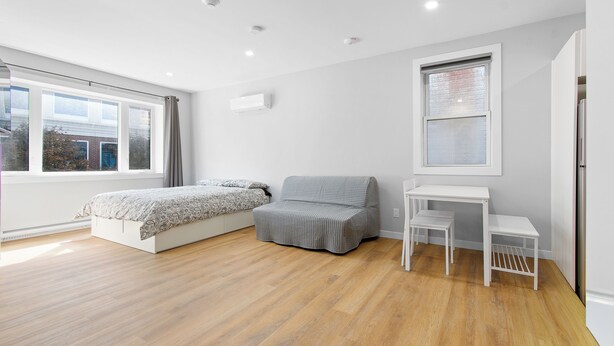 A modern bedroom with a bed, a sofa, a small table, and a window. - brand new downtown unit#9 (Gatineau)