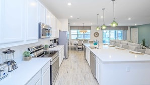 A modern kitchen with white cabinets, stainless steel appliances, and a central island. - Upstay - Magic Mansion w Pool-spa-cinema-games (Kissimmee)