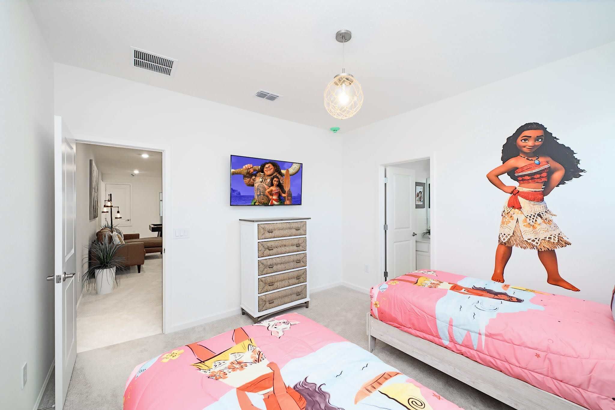 A bedroom with two beds, a TV, and a wall mural.