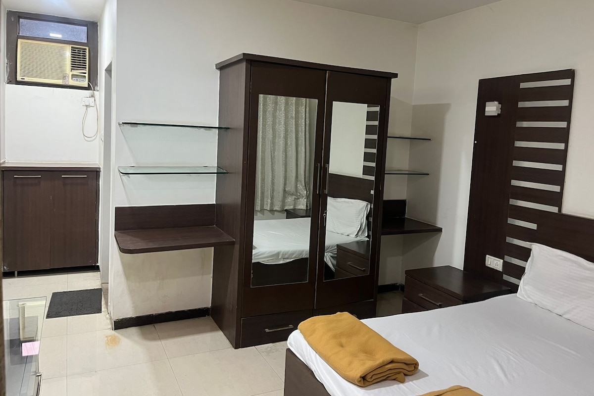 Un dormitorio con cama, armario con estantes de vidrio, mesita de noche y espejo.