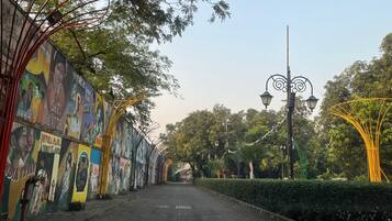 Un sendero bordeado por murales coloridos y faroles, que conduce hacia un arco lejano.