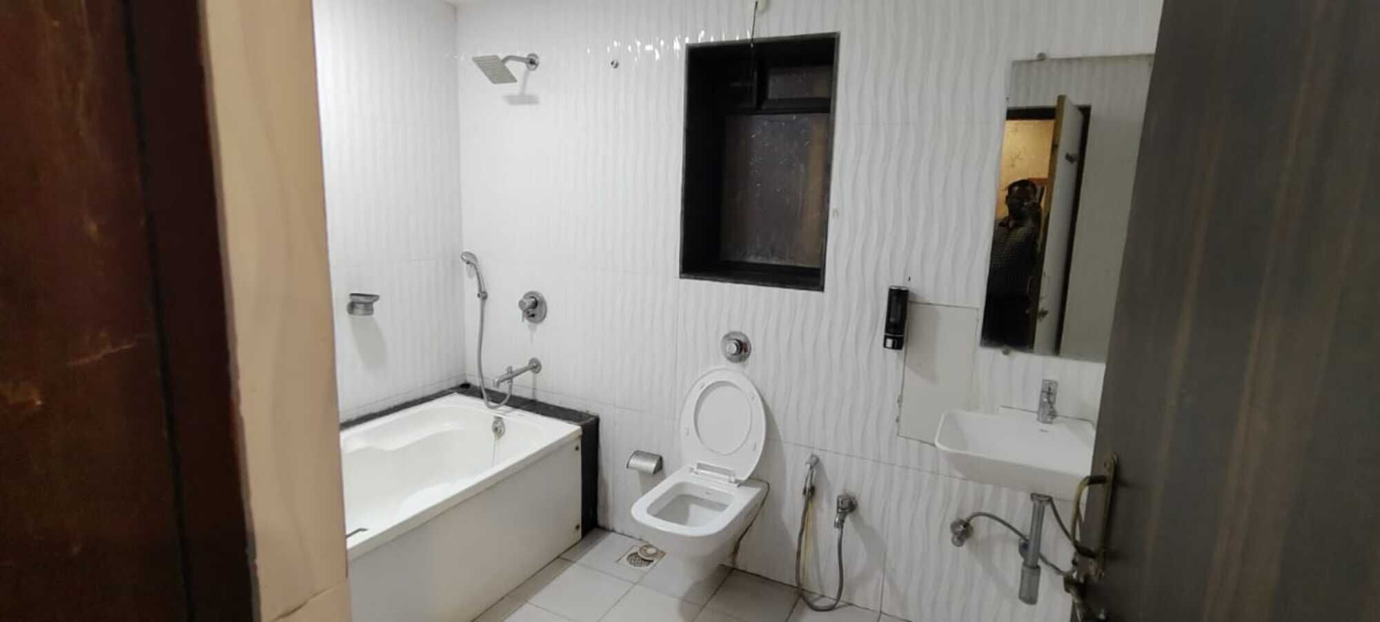 A bathroom with a bathtub, toilet, and sink.