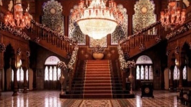 A grand staircase with ornate railings and a chandelier, leading to a higher floor. - ND Film City and Heritage Theme Resort (Khalapur)