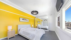 A hotel room with a bed, bedside tables, a mirror, and a window with a view. - Metawisebnb Cozy 2bed Earlwood Near City Airport (Sydney)