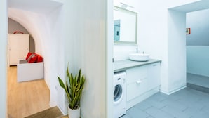 A modern bathroom with a sink, mirror, and washing machine. - O Panaro Lucky Flat by NapoliApartments (Naples)