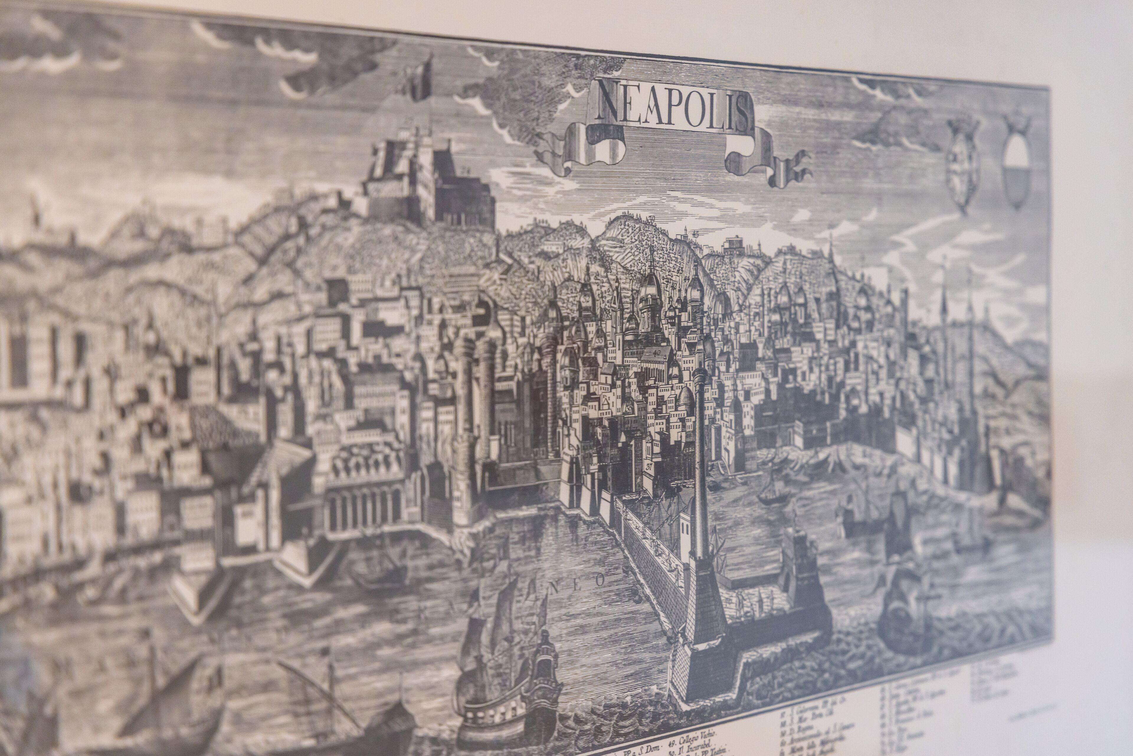 Une illustration détaillée en noir et blanc représentant un paysage urbain historique, avec des bâtiments remarquables et une rivière.