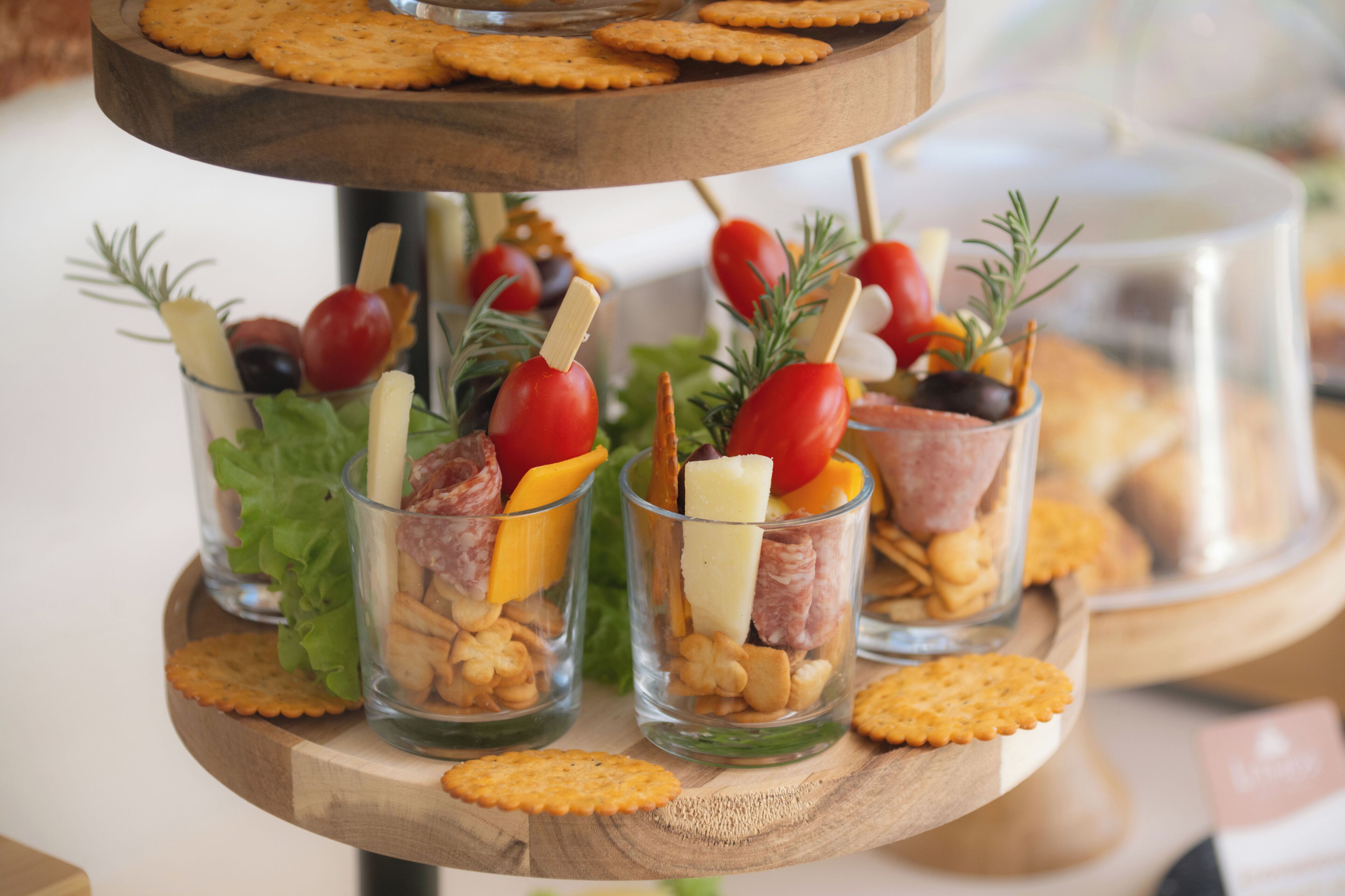 A multi-tiered serving tray with snacks and appetizers.