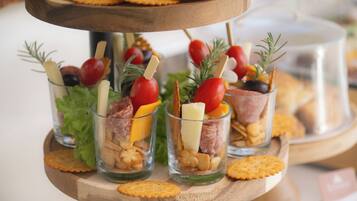A multi-tiered serving tray with snacks and appetizers.