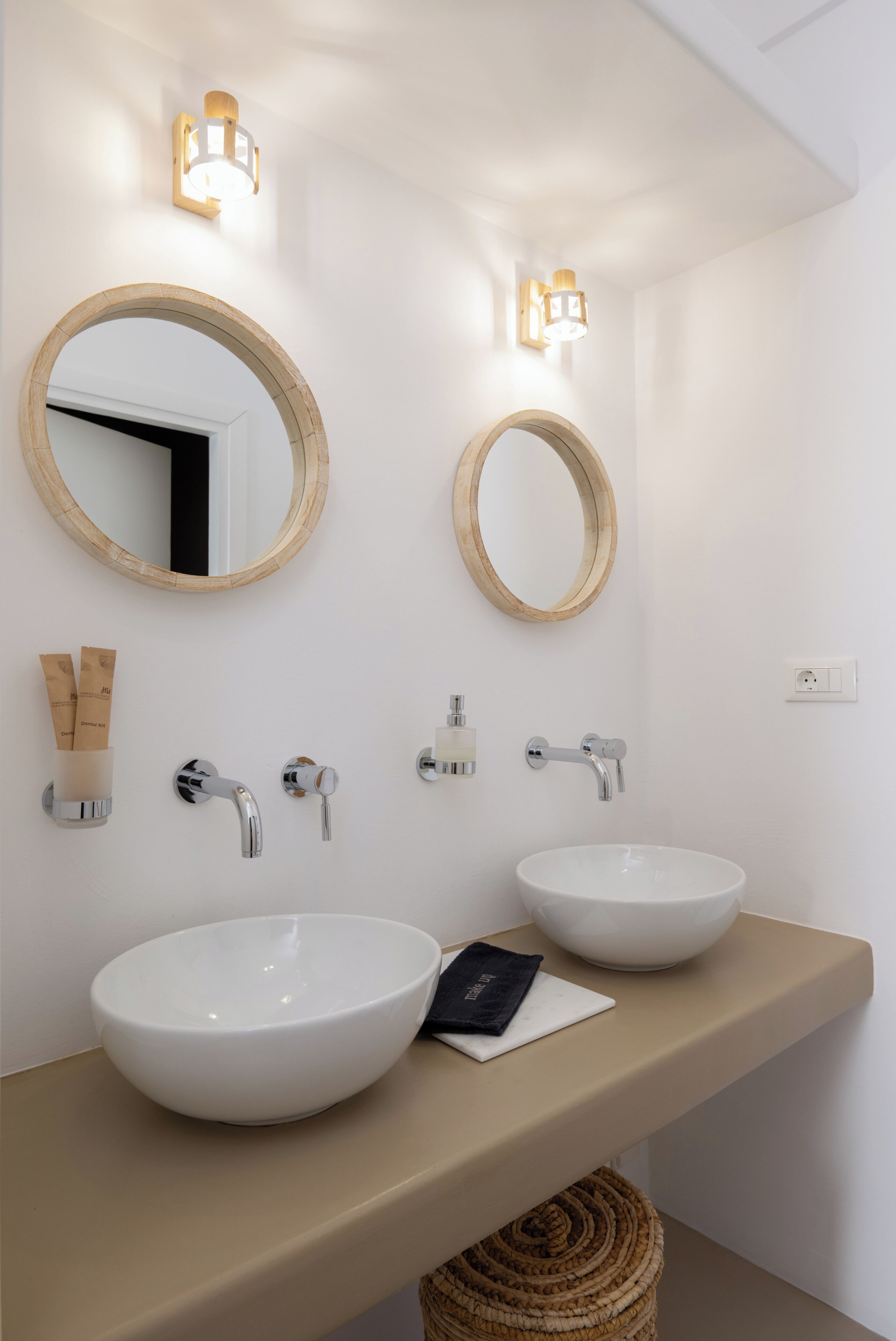 Une salle de bain avec deux lavabos, un miroir et des luminaires fixés au mur.