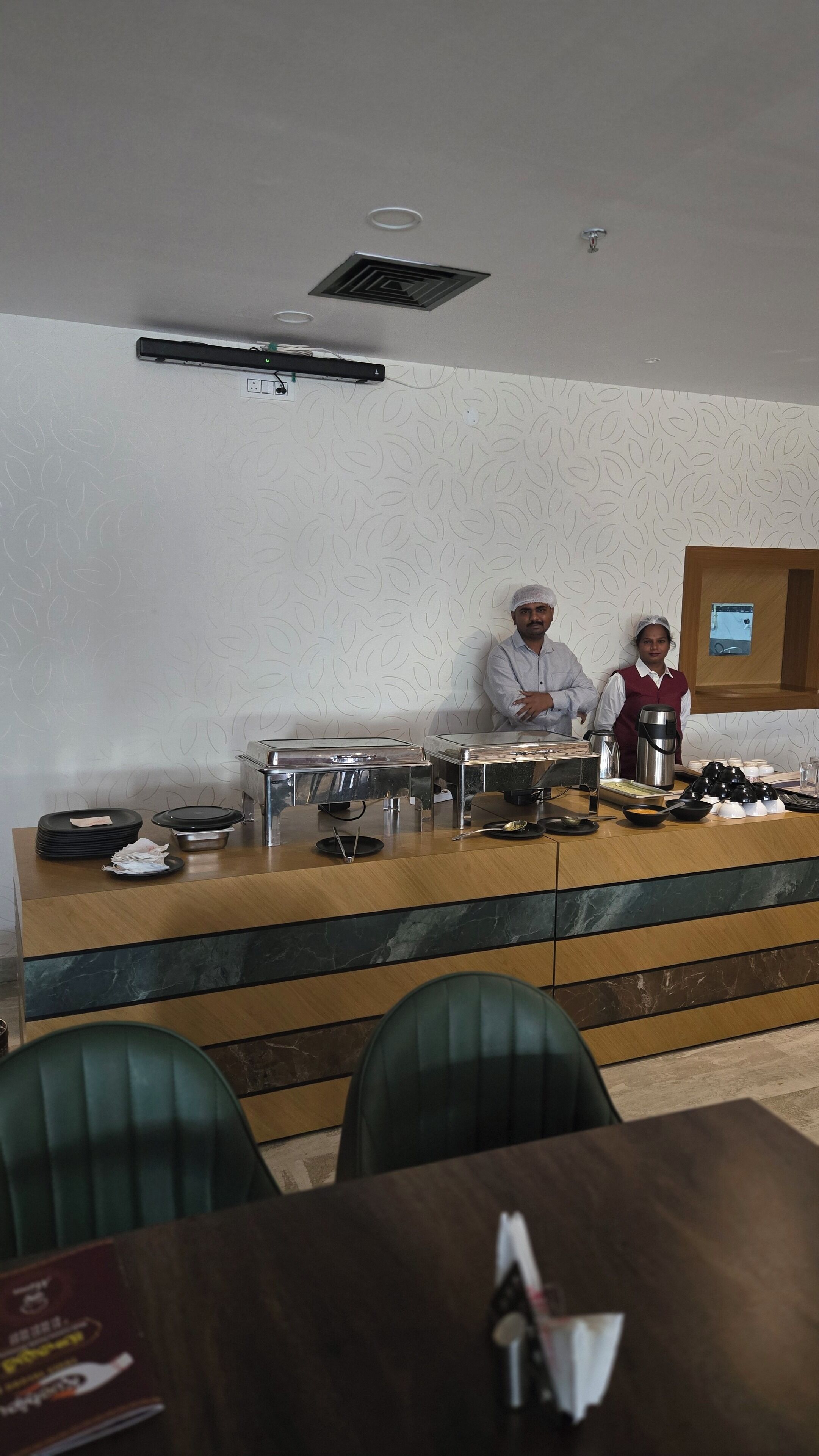 Een buffetopstelling met een toonbank, borden, kommen en een koffiepot.