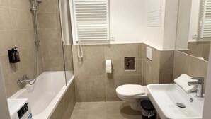 Un baño con bañera, inodoro y lavabo.
